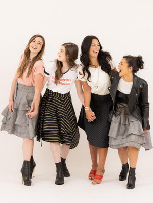 four friends holding hands and laughing wearing the Valerie wrap skirt.