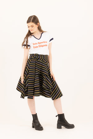 Woman in a graphic baseball tee and the Valerie multi colored wrap skirt in chunky heel booties.