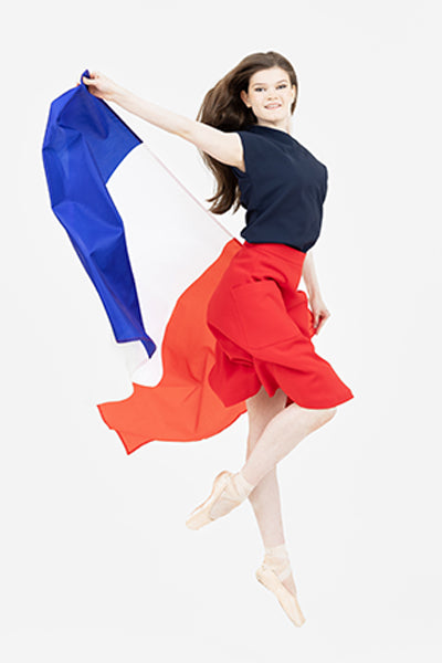 Ballerina dancing with the French flag wearing the Julie top in marine and the Mirielle skirt in red.