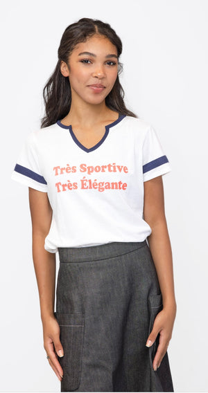 Young woman wearing a baseball tee that says “très sportive, très élégante.”

