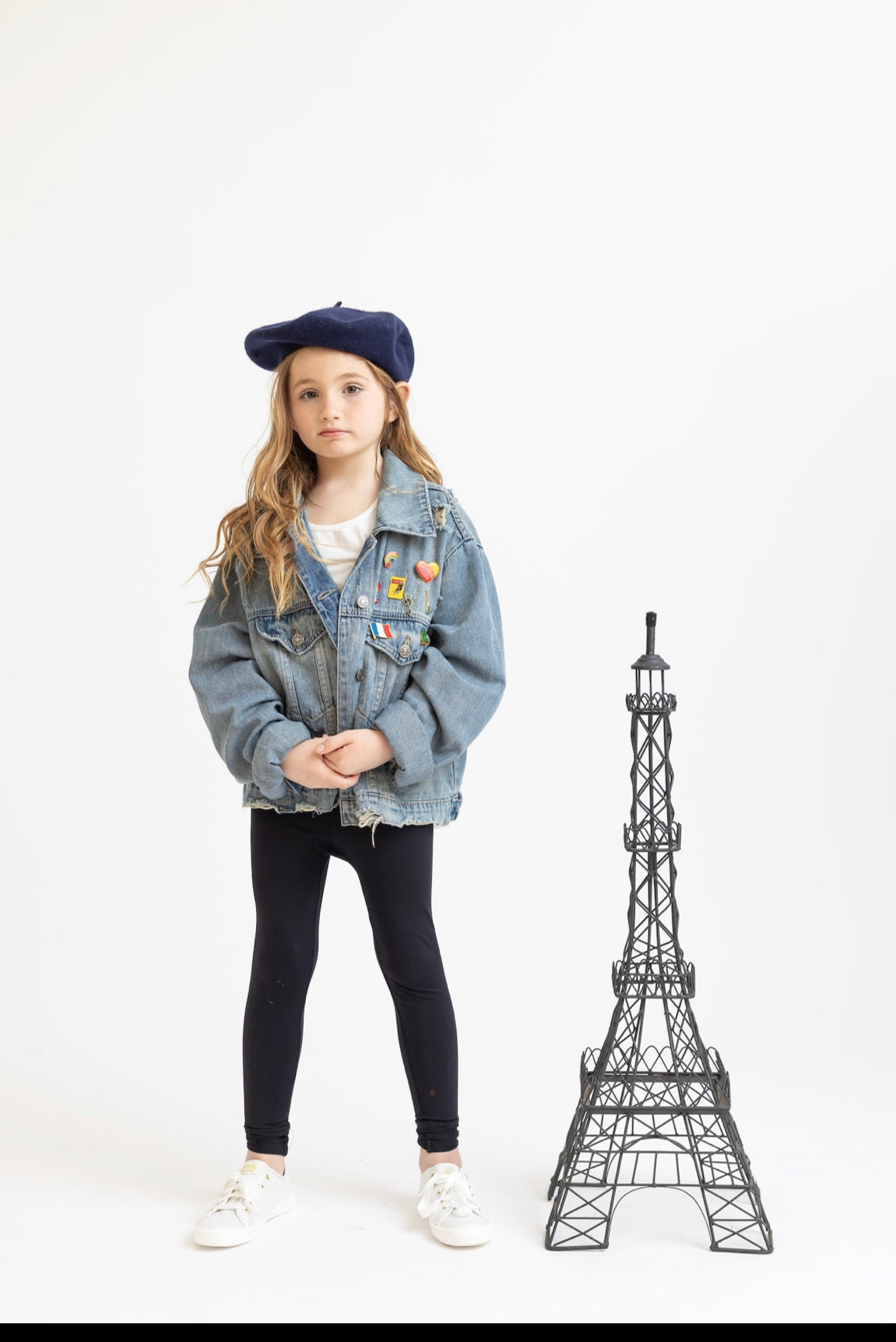Young French girl in a grown up woman&#39;s vintage jean jacket.