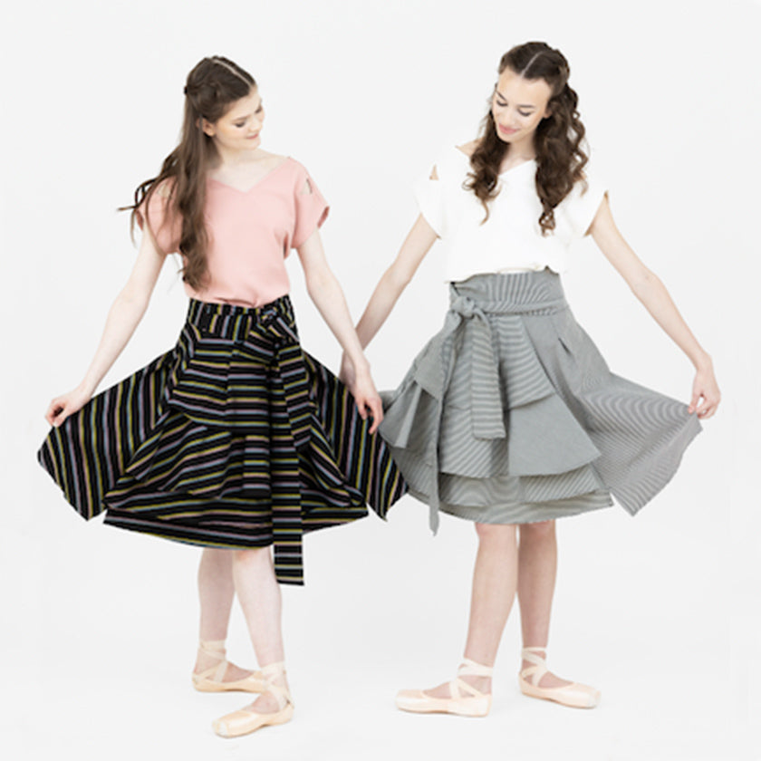 Two elegant ballerinas wearing the Valerie skirt, in two different patterns, the multi stripe and striped black and white.