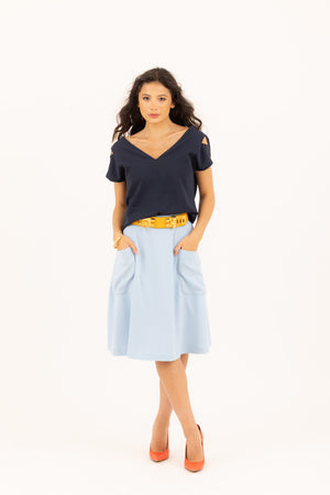 Chic raven haired woman wearing Julie double V top in marine/navy, and Mireille two pocket midi skirt in baby blue by Le Mireille Marche.