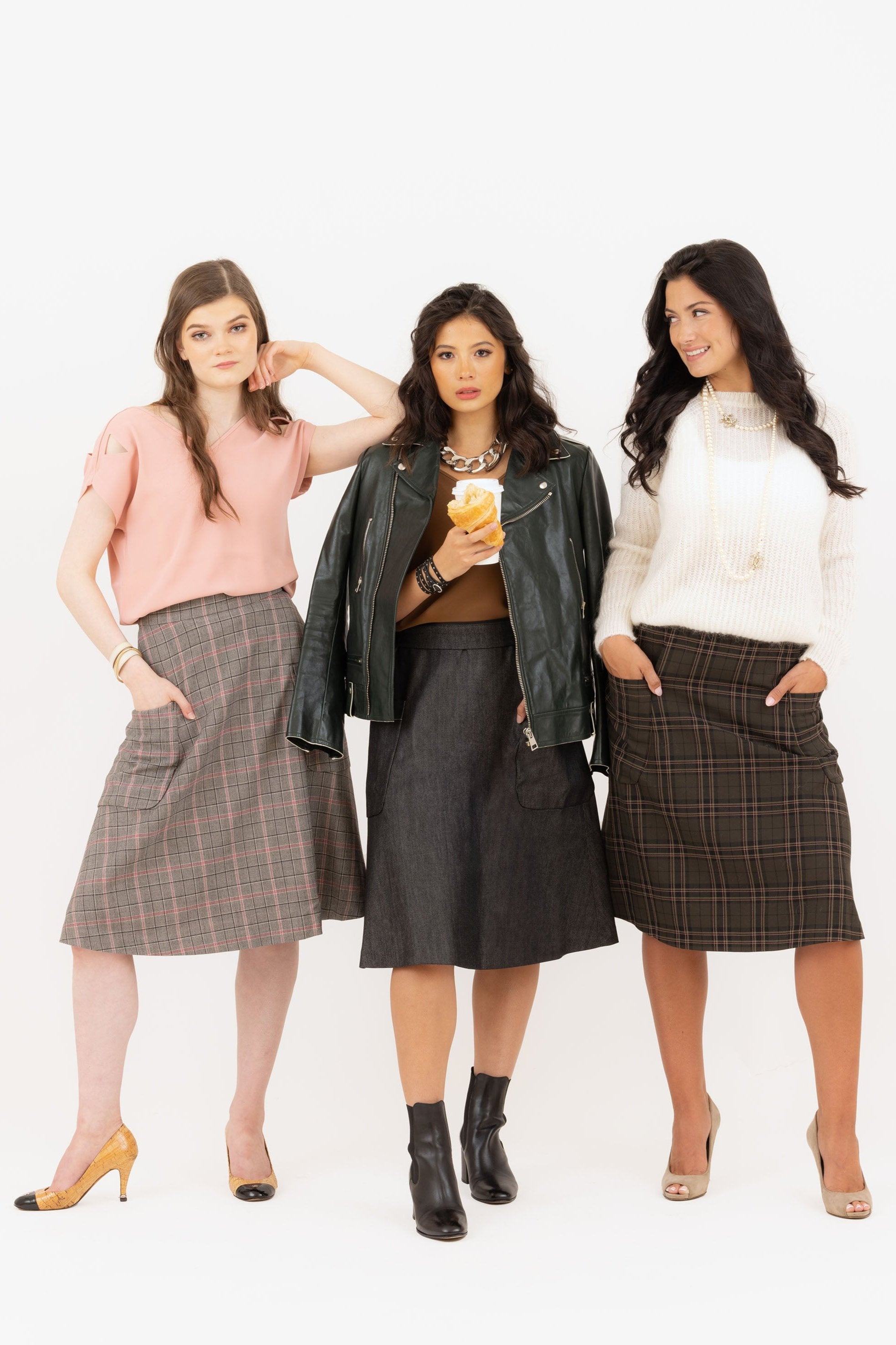 3 chic women wearing French 2 pocket midi skirts, one in denim and two in girly plaids.