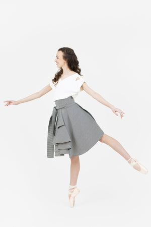 Ballerina on-pointe wearing the Valerie wrap skirt in black and white with the white V neck Julie top.