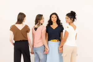 Four friends wearing the Julie top in different colors, photographed so the top can be seen from all angles.