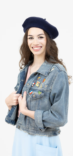 Beautiful woman in a French vintage inspired jean jacket with enamel pins.