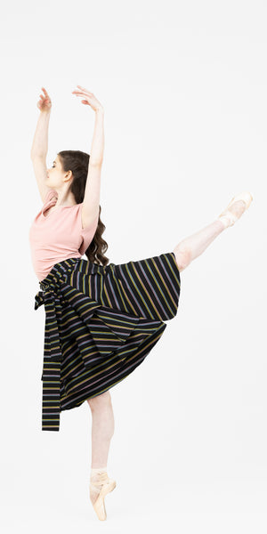 Ballerina on pointe in arabesque wearing the Valerie multi colour stripe wrap skirt and the pink V neck Julie top from Le Mireille Marche.